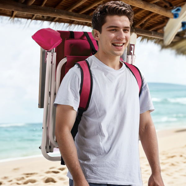 Man carrying a folded pink beach chair as a backpack with padded straps. Lightweight and portable design for easy transport.