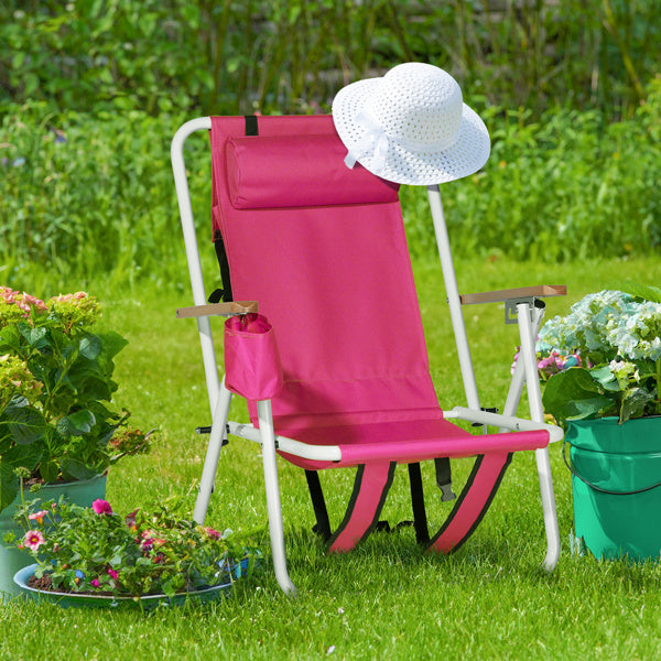 Pink beach chair placed on a green lawn with a white sun hat on top. Perfect for outdoor seating in gardens or parks.