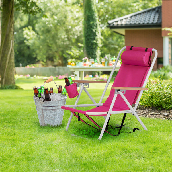 Pink beach chair set up on a grassy lawn near a bucket of cold drinks. Perfect for backyard relaxation and outdoor gatherings.