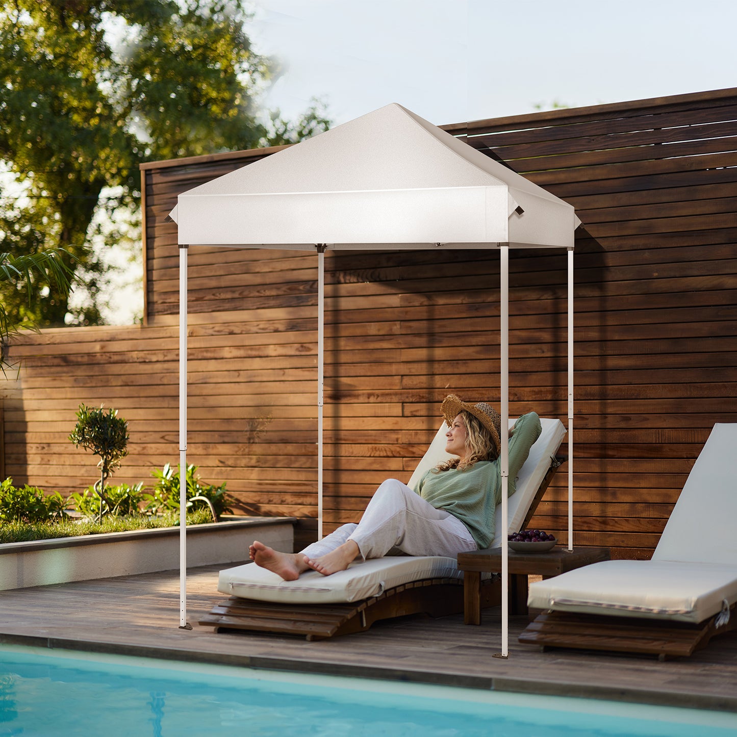 5X5ft white outdoor awning by a poolside, providing shade for a woman relaxing on a lounge chair. Ideal for patios, gardens, and outdoor spaces.